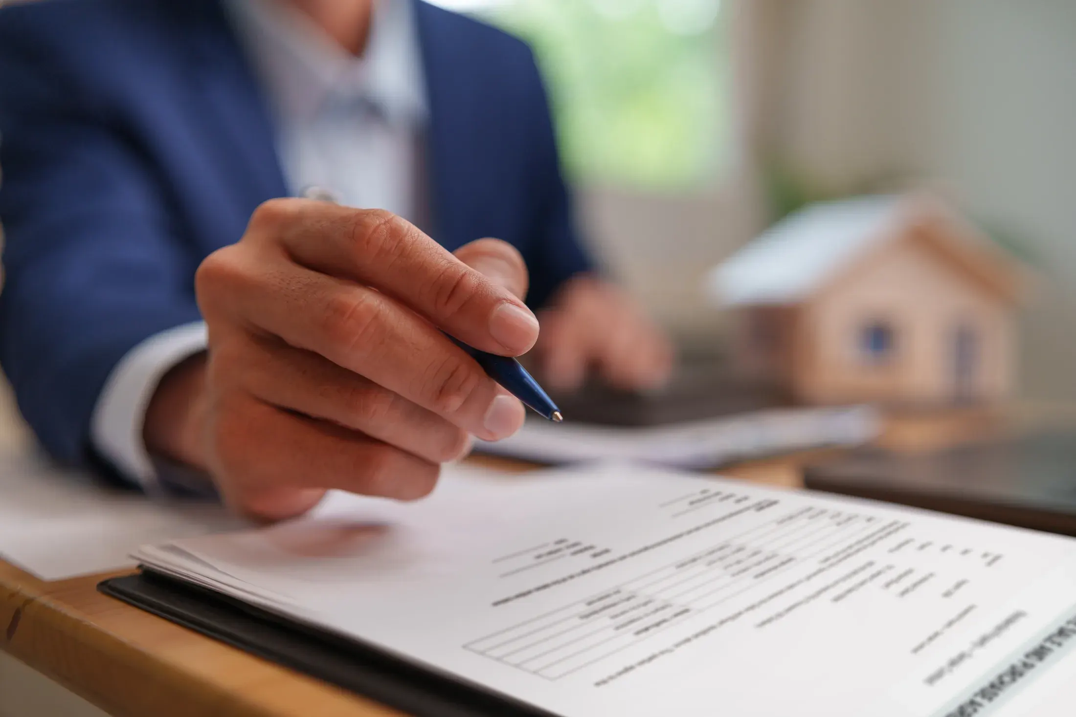 Close-up of a hand reviewing and signing a contract document, face not visible